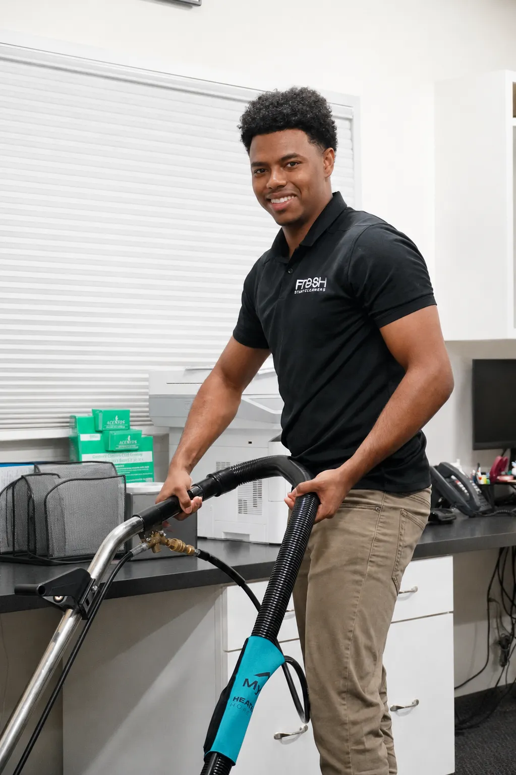 Fresh Start Cleaners technician smiling with carpet extraction equipment in a client facility